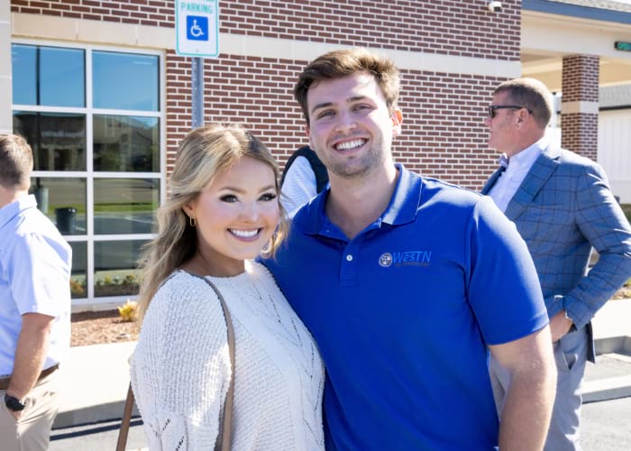 A worker of the West Tennessee Bank posing in front of the building for the 125th anniversary