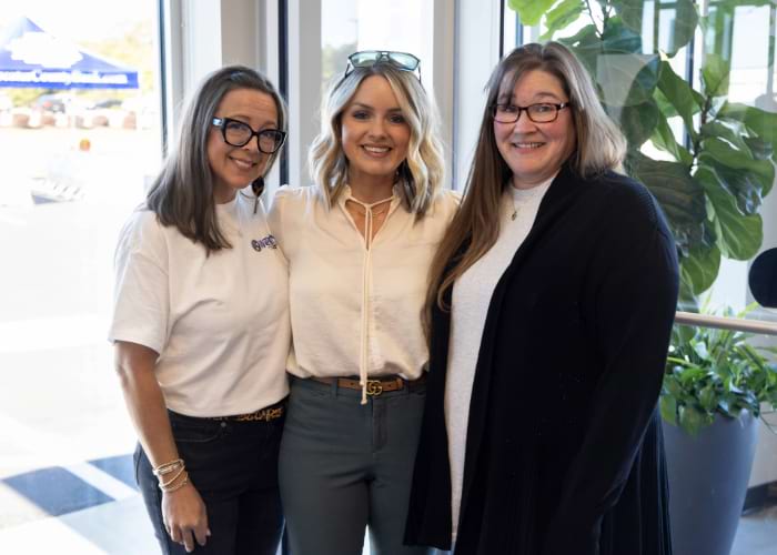 Three employees pose together inside the West Tennessee Bank for the Anniversary