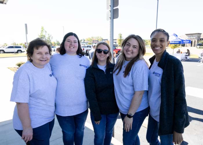 Five women with West Tennessee uniforms posing together for the celebration