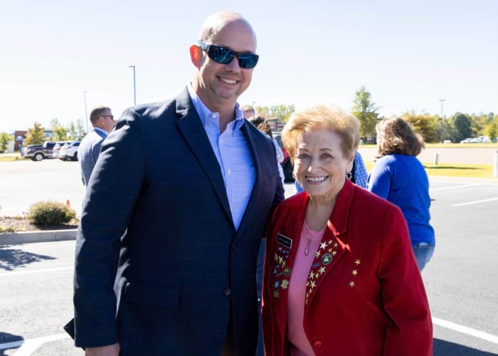 A man and his wife with a name-tag posing for the camera for the celebration