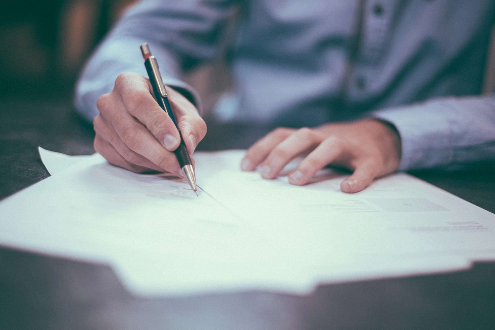 A person signing the privacy policy, with the document blurred out