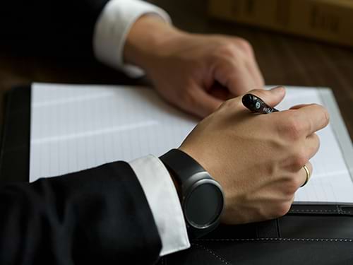 A businessman in a suit reviewing a printed document at his desk