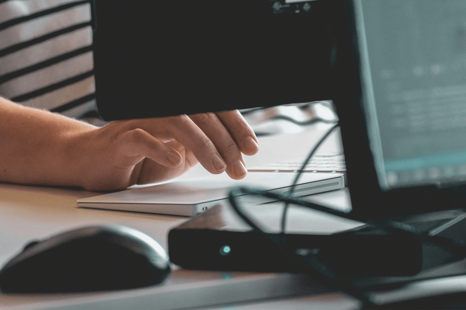 Behind the screen photo of person using a touch pad mouse